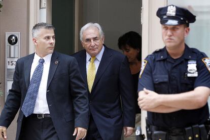 Dominique Strauss-Kahn y su esposa Anne Sinclair (en segundo plano) salen de su residencia en Manhattan, el 6 de julio de 2011.