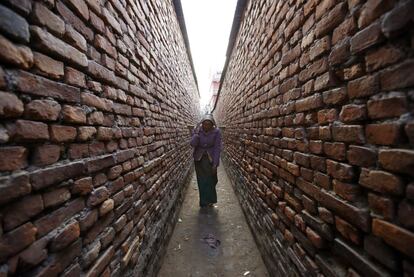 Una mujer camina por una calle de Katmandú (Nepal) cercana a un mercado de verduras.