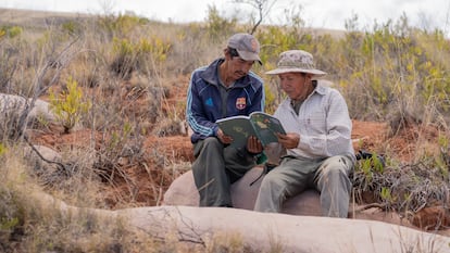 Men from an Indigenous community in Bolivia leaf through the recipe book.