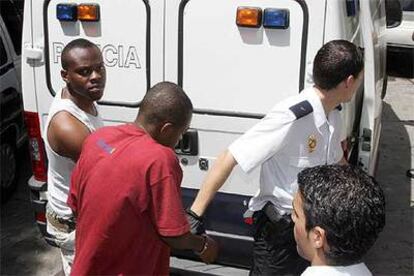 Un agente trasladaba ayer a dos detenidos en la <i>Operación Nilo</i> a los juzgados de Málaga.