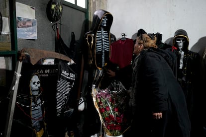 Una visitante toca una estatuilla de San La Muerte.