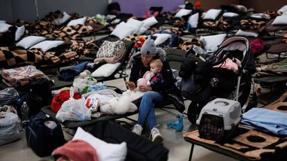 Una mujer con un bebé, en un centro comercial habilitado para los refugiados ucranianos en Mylny (Polonia), este domingo.