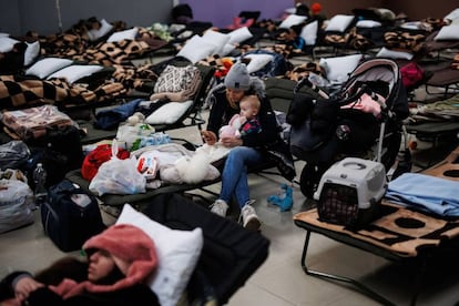 Una mujer con un bebé, en un centro comercial habilitado para los refugiados ucranianos en Mylny (Polonia), este domingo.