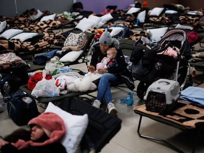 Una mujer con un bebé, en un centro comercial habilitado para los refugiados ucranianos en Mylny (Polonia), este domingo.