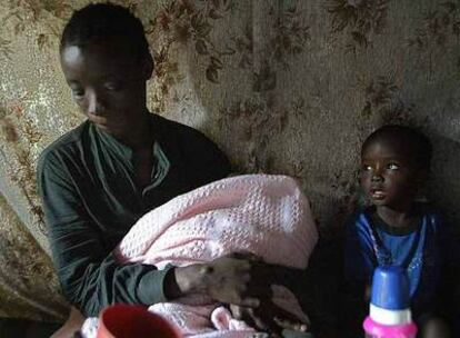Beatrice Akinyi, de 29 años, seropositiva, con su hijo Ibrahim, de tres años, y su bebé, en su casa de Kibera (Kenia). Contrajo la enfermedad hace cinco años.