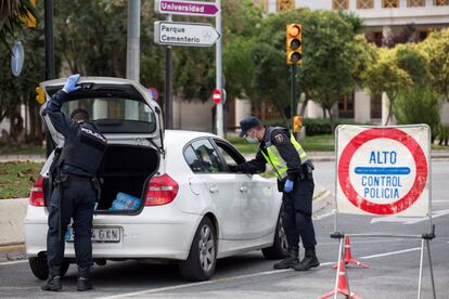 Agentes de la Policía Nacional realizan un control de tráfico en una de las salidas del casco urbano de Málaga, este domingo.