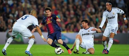 Pepe, Xabi Alonso y Özil intentan impedir el avance de Messi.