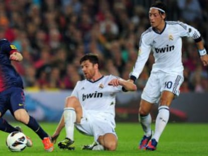 Pepe, Xabi Alonso y Özil intentan impedir el avance de Messi.