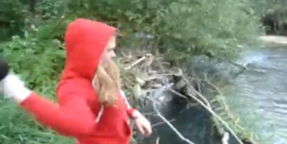 Imagen del vídeo en el que aparece una chica lanzando cachorros de perro a un río.