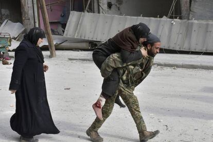 Soldado sírio socorre uma mulher ferida em Aleppo, após o Exército tomar o controle sobre a região. Milhares de civis aguardam para sair da cidade, devastada pela guerra que já dura cinco anos.