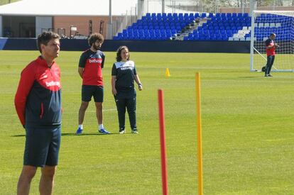 Jara Cuenca mira atenta el entrenamiento del CD Leganés; delante, el entrenador, Mauricio Pellegrino.