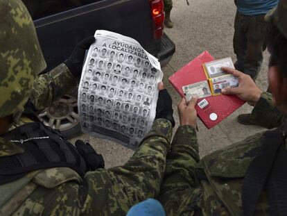 En una fotografía del 30 de septiembre de 2014, soldados revisan identificaciones en un retén, durante la búsqueda de los 43 estudiantes desaparecidos.