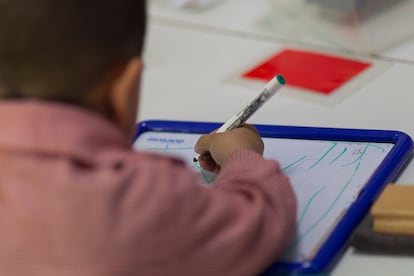 Un niño escribe en una pizarra.