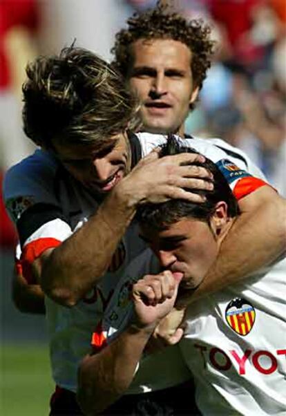 El jugador del Valencia David Villa (centro) es abrazado por sus compañeros David Albelda (izqda.) y Rubén Baraja tras meter un gol al Cádiz.