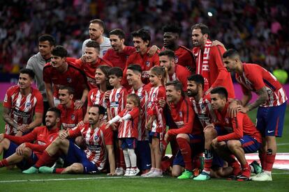 El delantero español del Atlético de Madrid Fernando Torres y sus hijos Nora, Leo y Elsa posan con sus compañeros durante un homenaje al final del partido de fútbol celebrado hoy en Madrid.