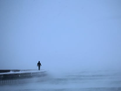 Un hombre camina a lo largo del lago Michigan al amanecer mientras las temperaturas rondan los -8 grados en Chicago.