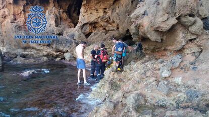 El equipo de rescate con el joven en la cala. / Polic&iacute;a Nacional