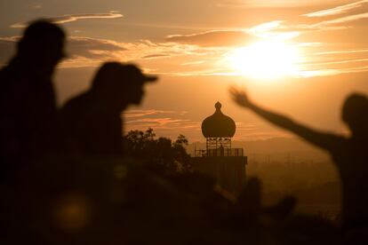 El sol se pone detrás de una torre que forma parte del decorado de Glastonbury, 24 de junio de 2014.