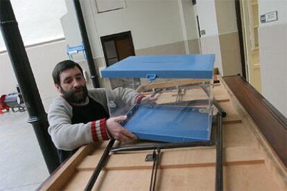 Una persona preparaba en la noche del viernes las mesas y las urnas para la jornada de hoy en un colegio electoral de San Sebastián.