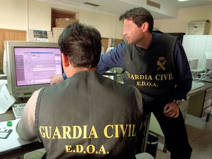 Dos agentes de la Guardia Civil rastrean delitos informáticos cometidos a través de Internet.