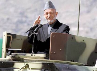 Karzai saluda a los asistentes durante el desfile militar de ayer, poco antes del atentado.