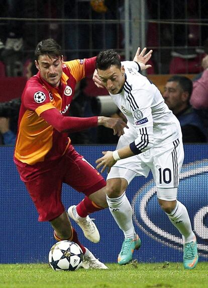 Özil lucha por el balón con Riera.