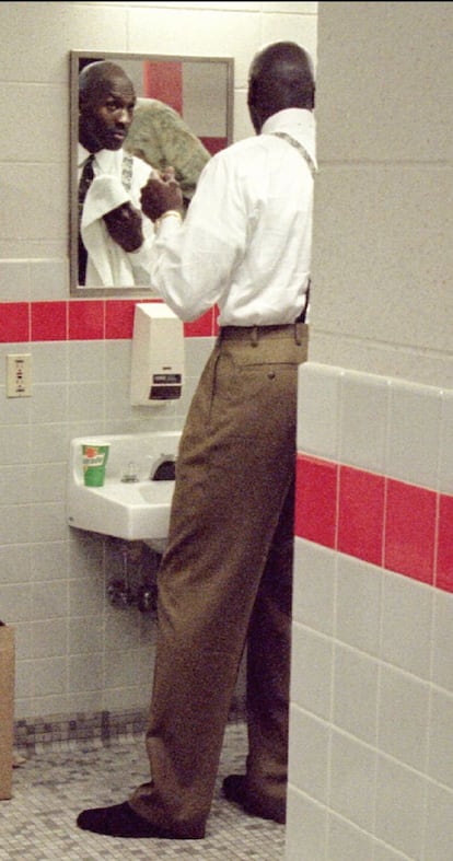 Michael Jordan se acicala en el vestuario de los Bulls antes de atender a la prensa.