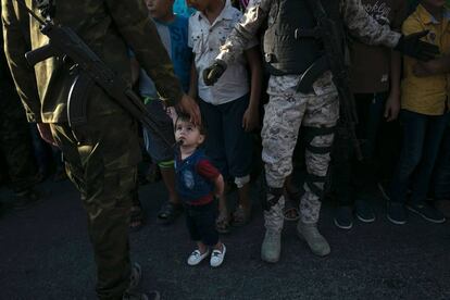 Un niño mira a un miembro de las Brigadas de Al Qassam, rama militar de Hamás, durante un desfile antiisraelí.