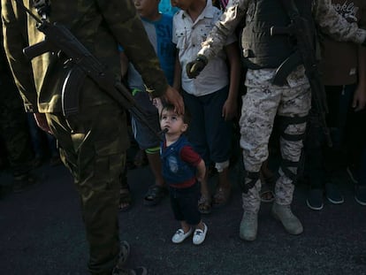 Un niño mira a un miembro de las Brigadas de Al Qassam, rama militar de Hamás, durante un desfile antiisraelí.