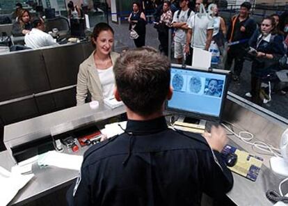 Un agente de aduanas toma las huellas a una pasajera en San Francisco.