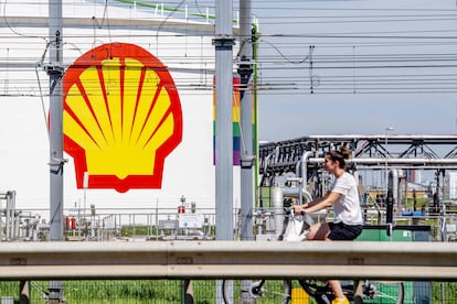 Una mujer pasea en bicicleta frente a la refinería de Pernis (cerca de Róterdam), propiedad de Shell y una de las mayores del mundo.