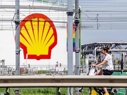 Una mujer pasea en bicicleta frente a la refinería de Pernis (cerca de Róterdam), propiedad de Shell y una de las mayores del mundo.