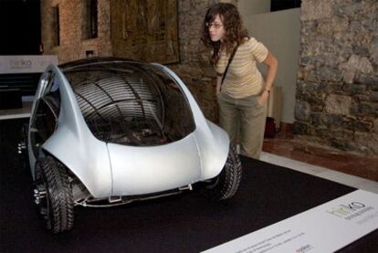Una joven observa un prototipo a escala 1:2 del coche eléctrico que está desarrollando el consorcio Hiriko.