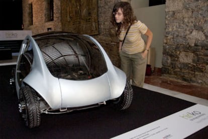 Una joven observa un prototipo a escala 1:2 del coche eléctrico que está desarrollando el consorcio Hiriko.