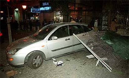 Un coche atravesado en una calle por los manifestantes radicales, que han utilizado el mobiliario urbano para sus acciones violentas.