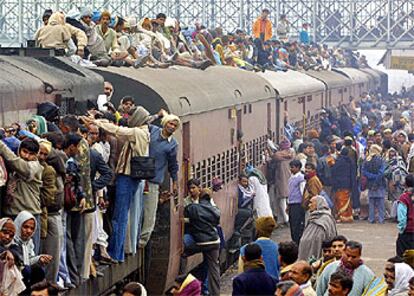 Peregrinos hindúes se arraciman en un convoy de ferrocarril en las inmediaciones de Alahabad para dirigirse a una celebración religiosa.
Un grupo de niños escarba en la basura almacenada en la orilla del río Yamuna, que pasa por Nueva Delhi.
