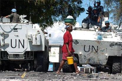 Una mujer haitiana pasa por delante de unos blindados de la ONU en un barrio de Puerto Príncipe.
