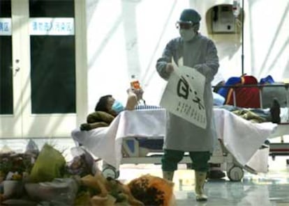 Un enfermo reposa en un pasillo de un hospital de Pekín.