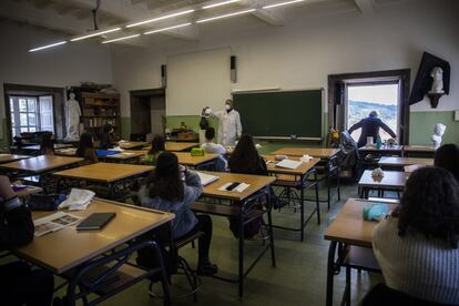 Alumnos de secundaria asisten a clase en el IES Rosalia de Castro en el centro de Santiago, donde se intenta ventilar las aulas lo maximo posible para evitar la propagacion de la COVID-19 después de que las autoridades sanitarias advirtieran de la posibilidades de que el virus se trasmite por aerosoles en entornos poco ventilados. En esta imagen el director del centro revisa la ventilacion de un aula en donde se está impartiendo clase.