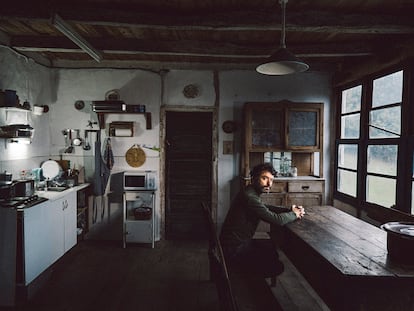 Rodrigo Sorogoyen sentado en la cocina de la casa donde rodó 'As bestas' en Quintela de Barjas, en el Bierzo leonés.