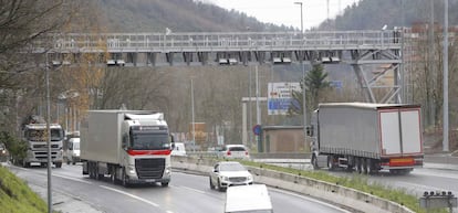 Camiones circulan por la N-I en Andoain (Gipuzkoa) bajo el arco que marca el peaje para vehículos pesados.