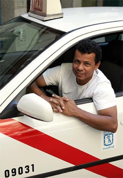 El colombiano Javier Santa Cruz, en el  taxi que conduce.