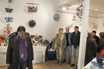 Al fondo, Elena, Rafael y Marcelino, tres de los autores que exponen sus obras en el centro sociocultural Aurelio Aguirre de Conxo.