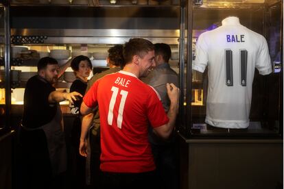 Un aficionado posa con la camiseta de Gales de Bale en el pub Elevens de Cardiff, propiedad del futbolista.
