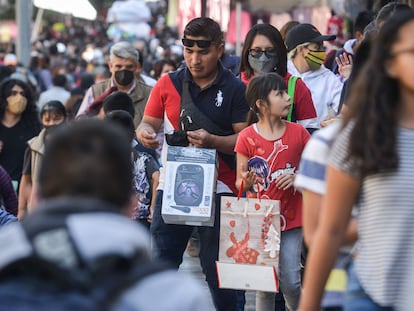 Una familia carga sus compras navideñas por una calle del centro histórico de Ciudad de México.