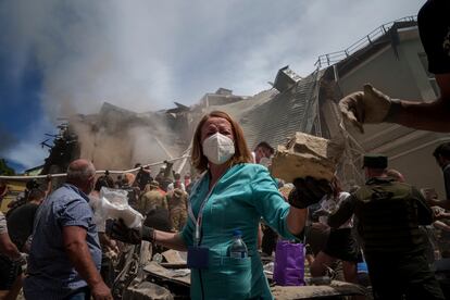 A health worker helps clear debris at the Okhmadit Children's Hospital this Monday following a Russian attack.  