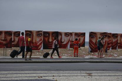 Un grupo de personas camina junto a una instalación a manera de manifestación organizada por la ONG Río de Paz en la playa de Copacabana, en Río de Janeiro, el pasado 6 de junio.