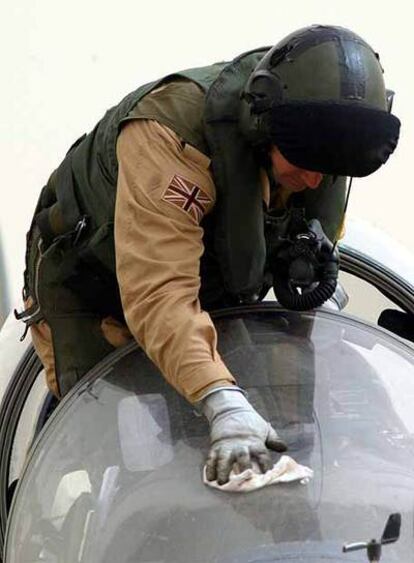 Un piloto británico limpia su avión Harrier.