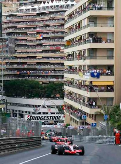Cientos de seguidores siguen la carrera, liderada por Alonso, desde los edificios cercanos al circuito.