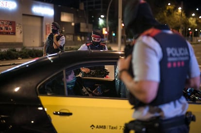 Catalan police officers at a curfew checkpoint in Barcelona on Sunday night.